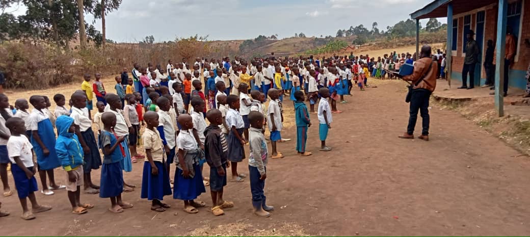 Schoolchildren gathered outdoors near a school building